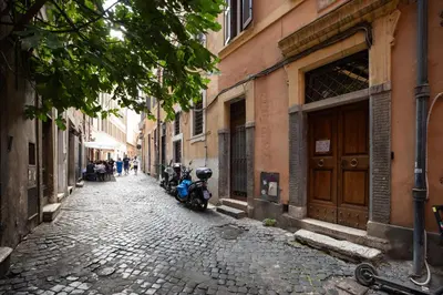 a cobblestone alley with two motorcycles parked on a street at iFlat Trevi's Paradise in Rome
