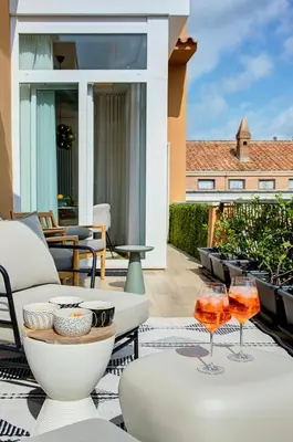 a patio with a table and two glasses of wine at Green Tevere Rooftop in Rome