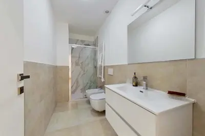a kitchen with white cabinets and a wooden floor at Hyaline Gregorio VII in Rome