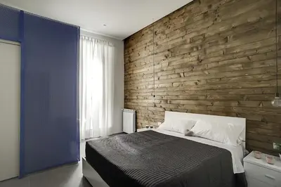 a bedroom with a wooden accent wall and a bed at B&B Girovagando in Rome