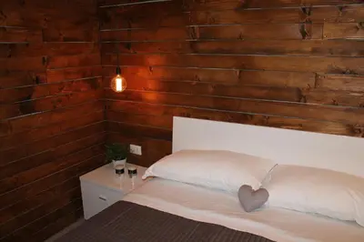 a bedroom with wooden walls and a bed with a heart pillow at B&B Girovagando in Rome