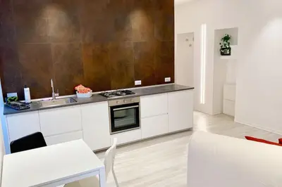 a kitchen with white cabinets and a sink and a stove at CasaFaleria in Rome