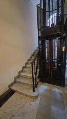 a staircase in a building with a wrought iron door at Luxury Apartment delle Fratte in Rome