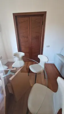 two white chairs and a glass table in a room at Luxury Apartment delle Fratte in Rome