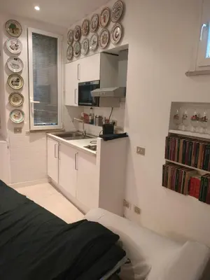 a white kitchen with plates on the wall at Euclide apartment in Rome