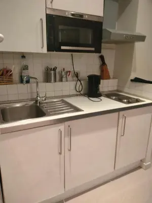 a kitchen with white cabinets and a sink and a microwave at Euclide apartment in Rome