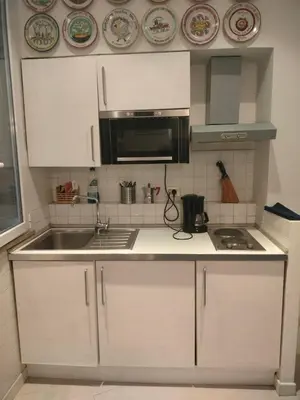 a kitchen with white cabinets and a sink and a microwave at Euclide apartment in Rome