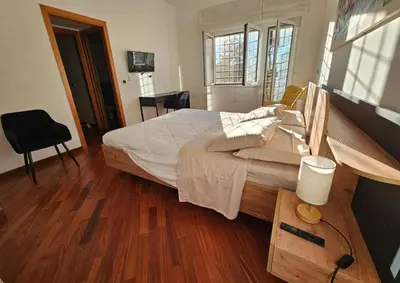a bedroom with a large bed with a wooden floor at Like at Home Gianicolense in Rome