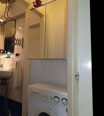 a kitchen with a washing machine and a sink at Green House Roma in Rome