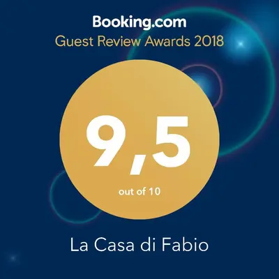a poster for the quest review awards in a yellow circle at La Casa di Fabio in Rome