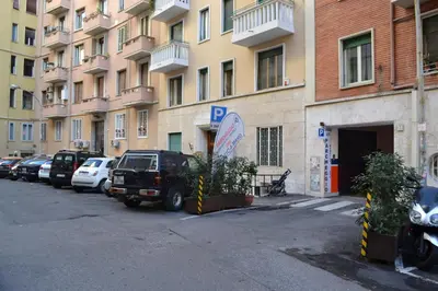 a parking lot with cars parked in front of a building at La Casa di Fabio in Rome