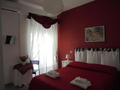 a red bedroom with two beds and a window at B&B Divina Roma in Rome