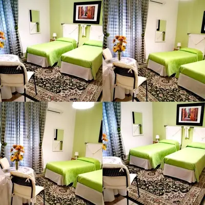 a hotel room with two beds and a table at B&B Divina Roma in Rome