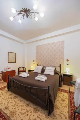 a bedroom with a large bed with two towels on it at B&B Divina Roma in Rome
