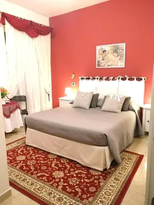 a bedroom with a large bed with red walls at B&B Divina Roma in Rome