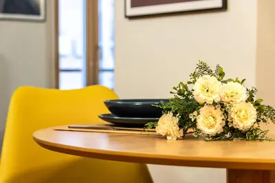 a table with a plate and flowers on it at The Hive - Holiday Home in Trastevere in Rome