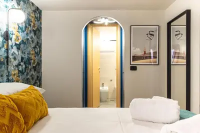 a bedroom with a white bed and a mirror at The Hive - Holiday Home in Trastevere in Rome