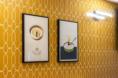 three framed pictures on a wall with gold wallpaper at The Hive - Holiday Home in Trastevere in Rome
