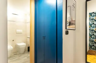 a blue door in a bathroom with a toilet at The Hive - Holiday Home in Trastevere in Rome