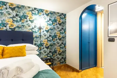 a bedroom with a blue door and a floral wall at The Hive - Holiday Home in Trastevere in Rome