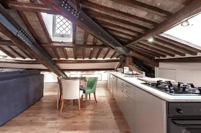 a kitchen with wooden ceilings and a table and chairs at Dimora Capo di Ferro in Rome