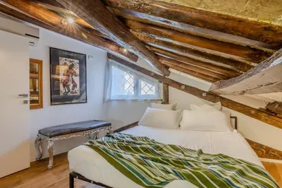 a bedroom with a bed in a room with wooden ceilings at Dimora Capo di Ferro in Rome