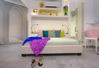 a bedroom with a white bed with colorful pillows at Exclusive retreat between history and comfort in Rome