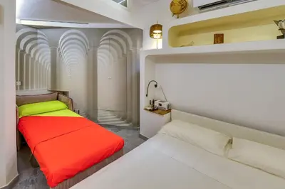 a bedroom with two beds with red and yellow at Exclusive retreat between history and comfort in Rome