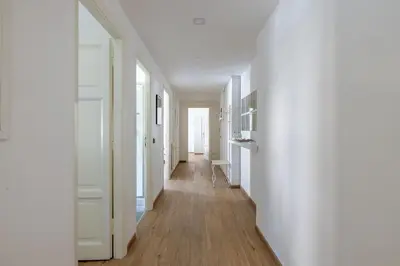 an empty hallway with white walls and wood floors at Casa EMMA, casa vacanze Aurelio in Rome