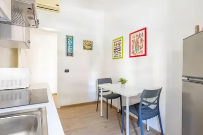 a small kitchen with a white table and chairs at Casa EMMA, casa vacanze Aurelio in Rome