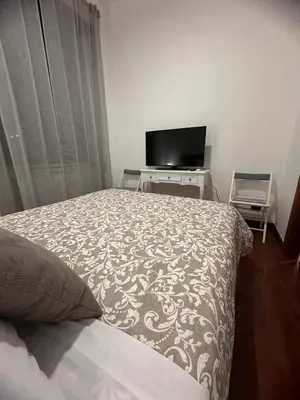 a bedroom with a bed and a flat screen tv at L'Attichetto di via Padova in Rome