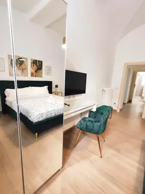 a bedroom with a bed and a chair and a television at The Gold Apartment in Rome