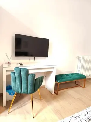 a living room with a desk and a green chair at The Gold Apartment in Rome