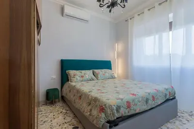 a bedroom with a bed with a blue headboard at Rebecca Apartment in Rome