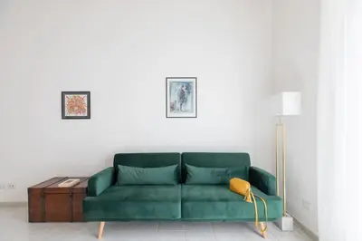 a green couch in a living room with a lamp at HospitalityRome Sunny San Lorenzo in Rome