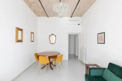 a living room with a table and yellow chairs at HospitalityRome Sunny San Lorenzo in Rome