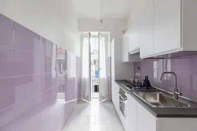 a white kitchen with a sink and a stove at HospitalityRome Sunny San Lorenzo in Rome