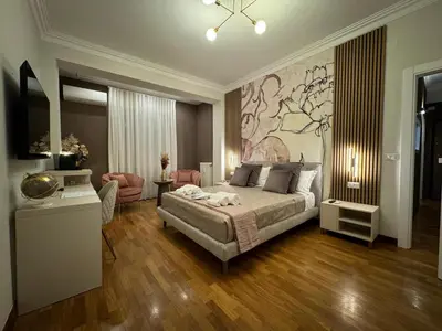 a bedroom with a bed and a painting on the wall at Querini Suite Roma in Rome