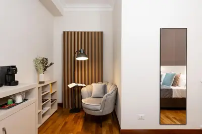 a living room with a chair and a bed at Querini Suite Roma in Rome