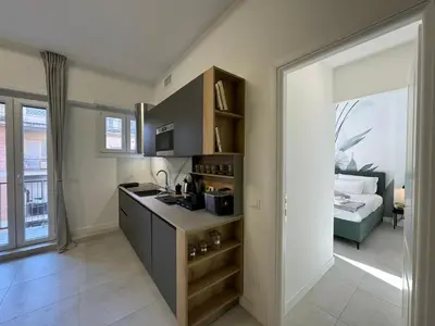 a kitchen with a counter and a room with a bed at Numiro in Rome