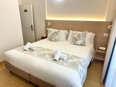 a bedroom with a large white bed with towels on it at May Home Guest House in Rome