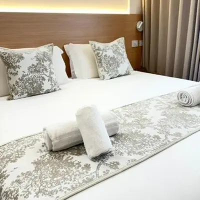 two beds in a hotel room with white sheets and pillows at May Home Guest House in Rome