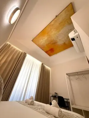 a bedroom with a bed and a painting on the wall at May Home Guest House in Rome