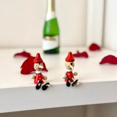 two small figurines on a shelf with a bottle of wine at May Home Guest House in Rome