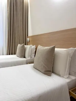 two beds in a hotel room with white sheets and pillows at May Home Guest House in Rome