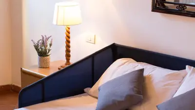 a bed with a blue headboard and a lamp on a table at Scala Studio by Rental in Rome in Rome