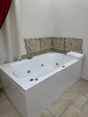 a large white bath tub in a bathroom at Jacuzzi Rooms Vatican Museum in Rome