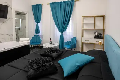 a bedroom with a large bed with blue pillows at Jacuzzi Rooms Vatican Museum in Rome