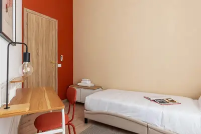a small room with a bed and a desk at Kaizen The Barista 3BR Apartment With Coffee Station in Rome