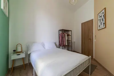 a bedroom with a white bed and a closet at Kaizen The Barista 3BR Apartment With Coffee Station in Rome